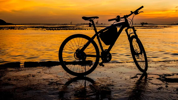 Silhouet van fiets op de steiger met zonsondergang hemel en zee pagina — Stockfoto