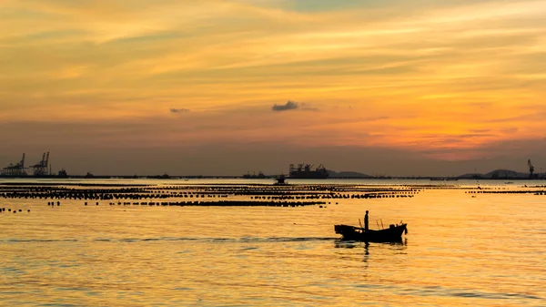 Силует дрібного рибальського човна в морі з небом заходу сонця — стокове фото