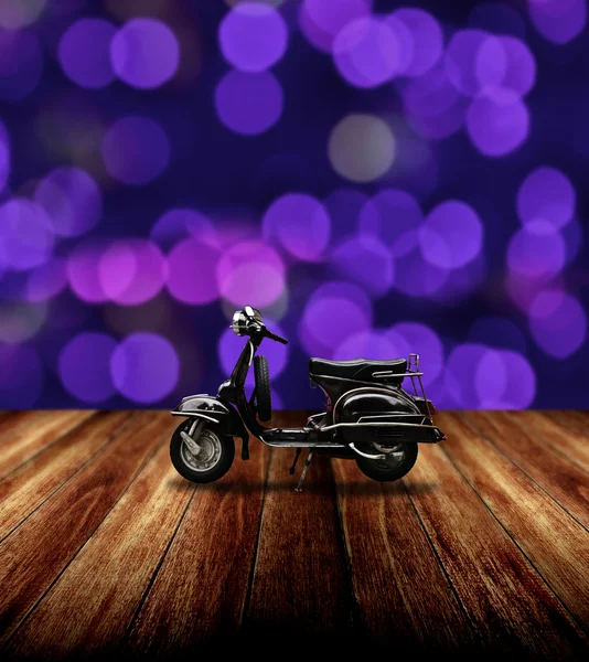 Classic motorbike parking on wooden floor with purple bokeh light — Stock Photo, Image