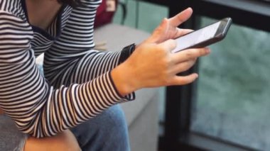 Kadın el ele tutuşup akıllı telefon kullanıyor.