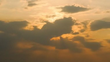 Akşam vakti gökyüzü arka planında bulutların arkasında günbatımı ışınlarının zaman aşımı