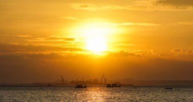 Balıkçı teknesi ve ticari rıhtım geçmişiyle güzel bir gün batımı gökyüzü