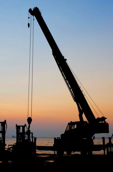 Silhouetten-Kran bei der Arbeit im Hafen — Stockfoto