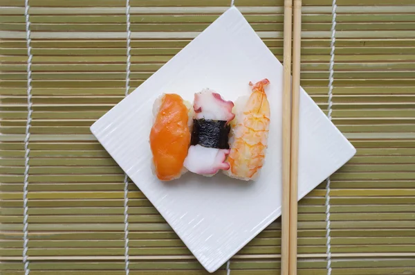 Суши нигири в блюде с бамбуковыми палочками — стоковое фото