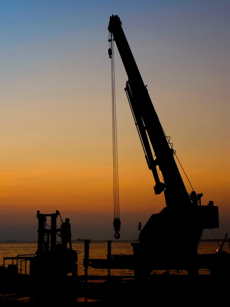 Silhouette crane working at port — Stock Photo, Image
