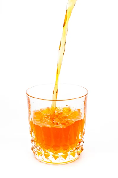 Наливаючи апельсиновий сік у склянку ізольовано — стокове фото
