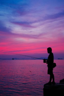 Deniz kenarında Balık tutma adam silüeti
