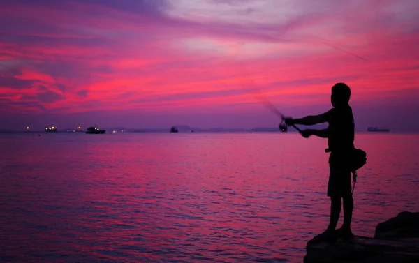 Silhueta de homem pescando ao lado do mar — Fotografia de Stock