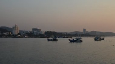 Zaman atlamalı günbatımı gökyüzü ile iskelesi yanındaki balıkçı teknesi