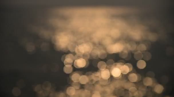 Bokeh de luz del atardecer reflejan en la ola en el mar (fondo borroso ) — Vídeos de Stock