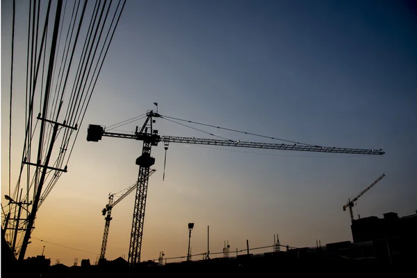 Silueta de grúa de construcción con cielo al atardecer —  Fotos de Stock