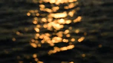 Bokeh günbatımı ışık yansıtacak dalga deniz (bulanık odak arka plan için)