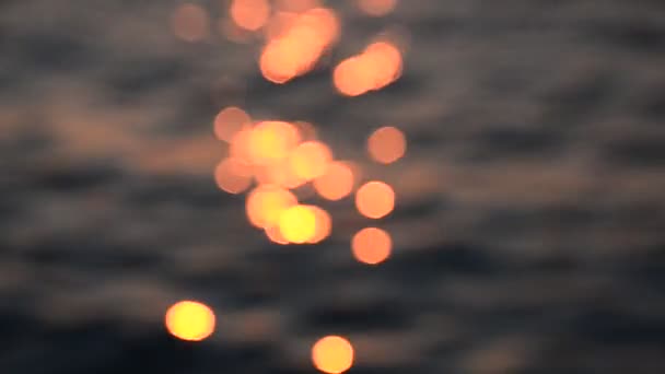 Bonita luz del atardecer bokeh en la onda del mar, fondo de luz borrosa — Vídeos de Stock