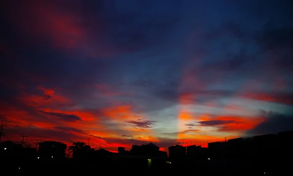 Fin solnedgång ljus skina på himlen med stadens siluett — Stockfoto