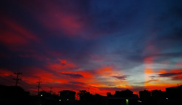 Bonita luz del atardecer brillan en el cielo con silueta de ciudad — Foto de Stock