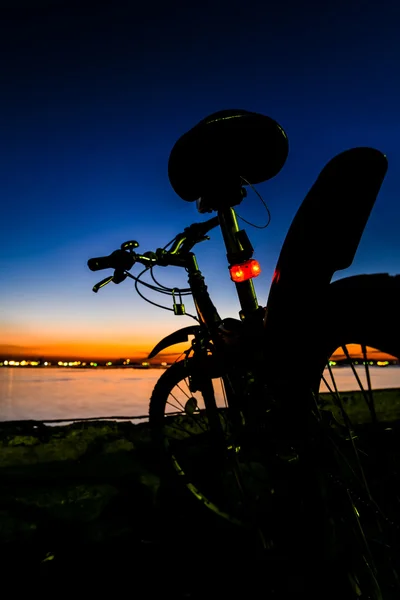 Górski rower zpowrotem obok morze niebo zmierzch — Zdjęcie stockowe