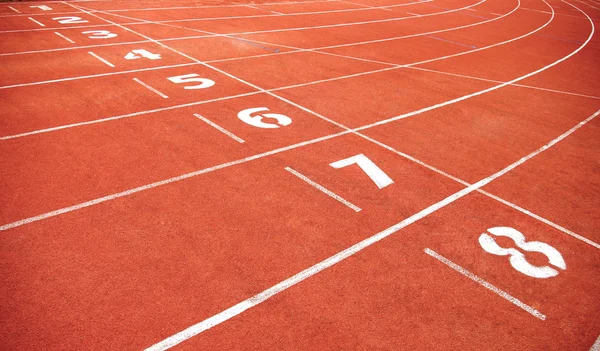 Cinta de correr roja en el estadio con la numeración de uno a ocho — Foto de Stock