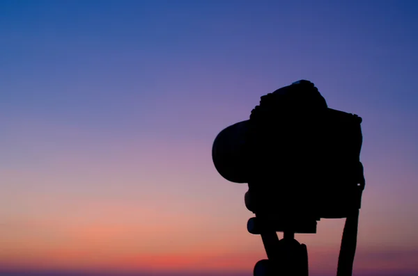 Silhouette einer DSLR-Kamera auf See mit Sonnenuntergang — Stockfoto