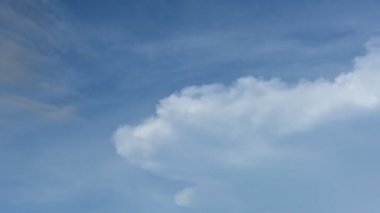 Mavi gökyüzünde rüzgarla yayılan bulutun zaman atlamalı