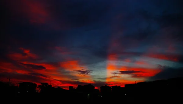 Mooie zonsondergang licht schijnen op de hemel met stad silhouet — Stockfoto