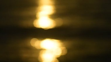 Deniz su yüzeyinde günbatımı ışığın soyut bokeh