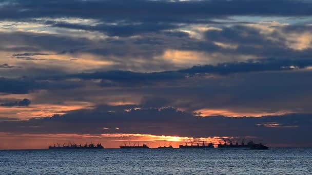 Céu de pôr do sol no mar com silhuetas de navios de carga — Vídeo de Stock