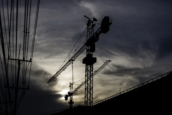 Silhouette des Krans auf Gebäude mit Sonnenuntergang Himmel Hintergrund — Stockfoto