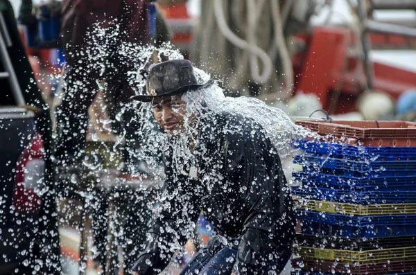 Kimliği belirsiz işçi iskeleye yıkama balıkçı teknesi — Stok fotoğraf