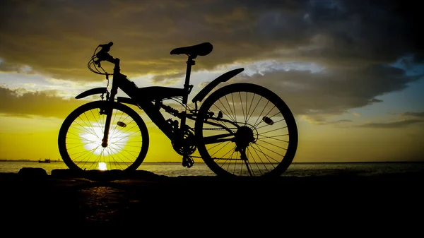 Silhuett av mountainbike med solnedgång himlen vid havet — Stockfoto