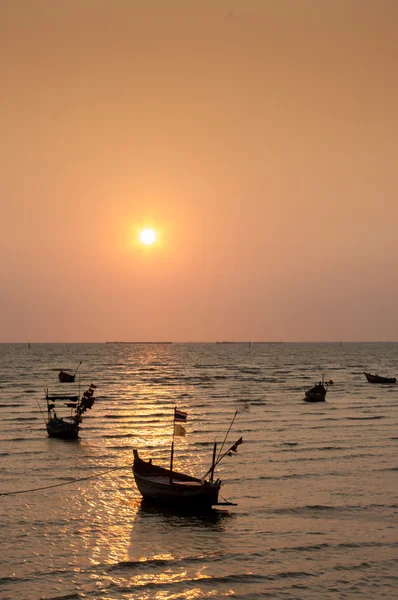 Halászhajó, úszó tengerparton napnyugtakor ég háttér — Stock Fotó