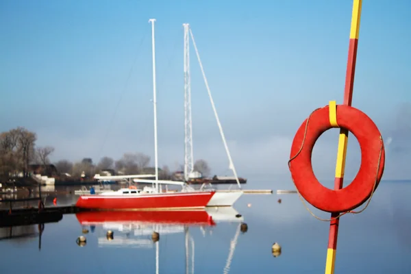 İki yat bir arka plan üzerinde kırmızı lifebuoy