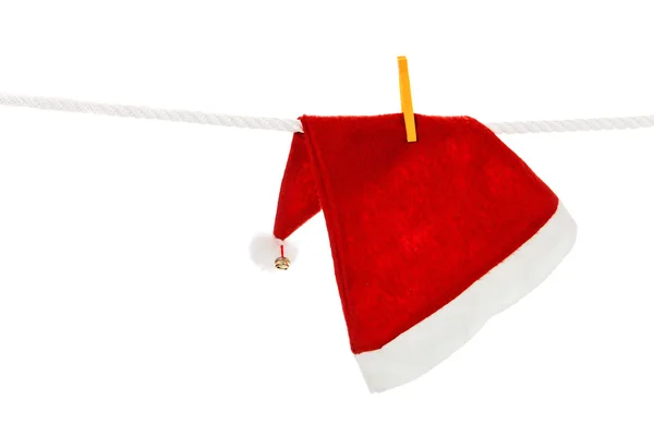 Weihnachtsmannmütze hängt an weißem Seil — Stockfoto