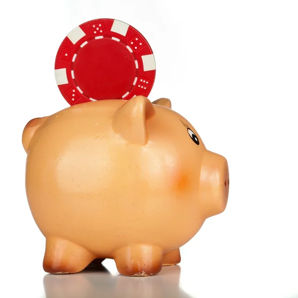 Poker chip falling into a piggy bank — Stock Photo, Image