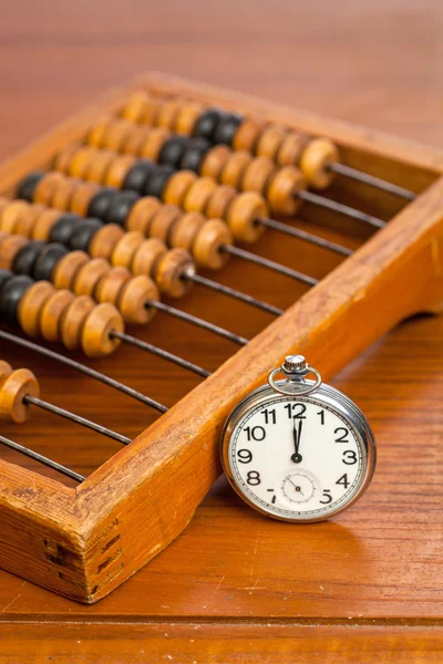 Pocket watch next to abacus — Stock Photo, Image