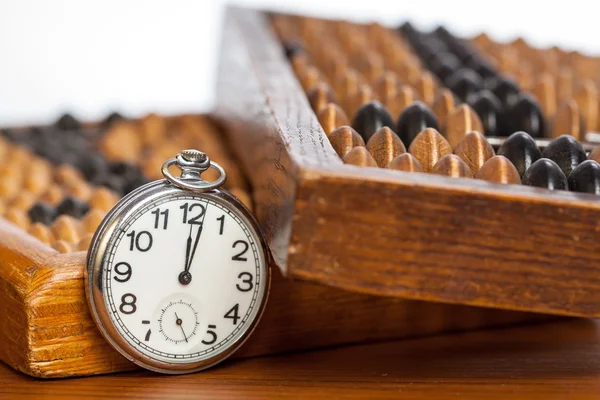 Pocket watch next to abacus — Stock Photo, Image