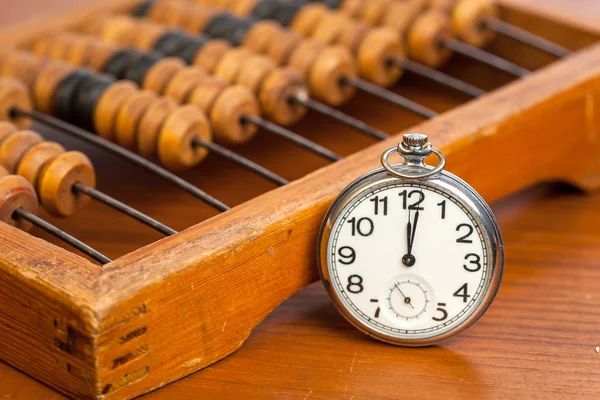 Pocket watch next to abacus — Stock Photo, Image