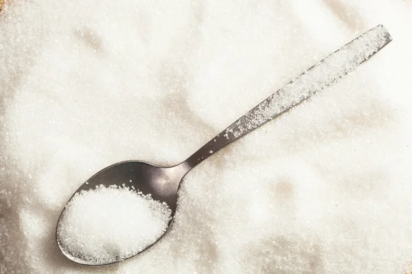 Löffel in einem Haufen Zucker — Stockfoto