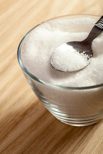 Spoon in a bowl of sugar — Stock Photo, Image