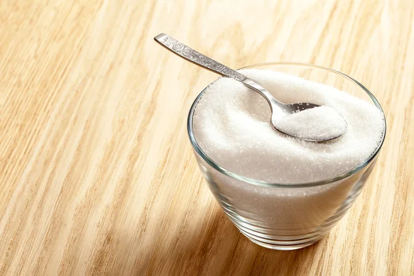 Spoon in a bowl of sugar — Stock Photo, Image