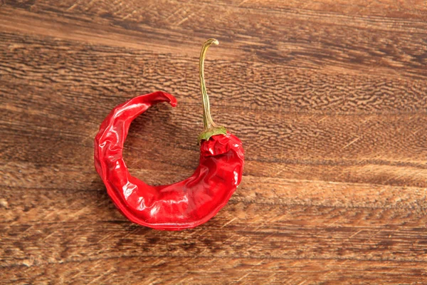 Bent red hot chilli pepper on a table — Stock Photo, Image