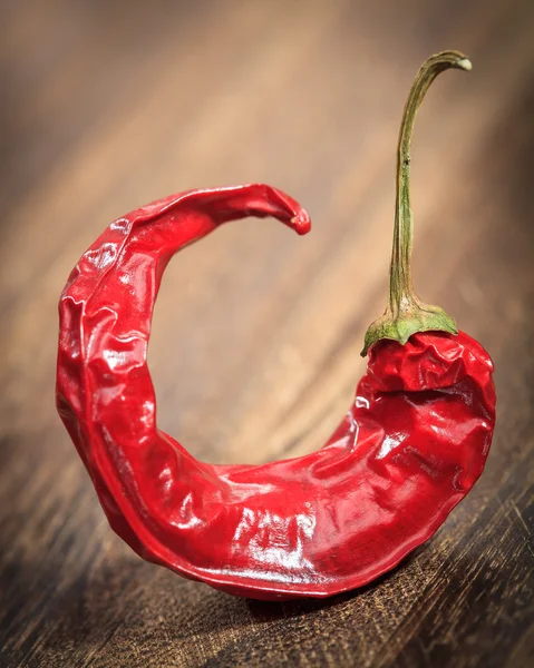 Bent red hot chilli pepper on a table — Stock Photo, Image