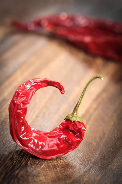 Bent red hot chilli pepper on a table — Stock Photo, Image