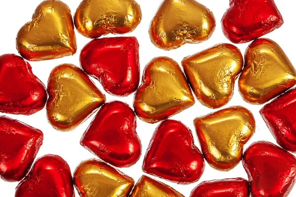 Красные и желтые шоколадные конфеты на белом — стоковое фото