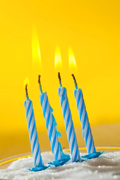 Quatre bougies d'anniversaire sur fond jaune — Photo