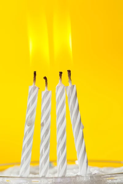 Burning white candles over yellow background — Stock Photo, Image