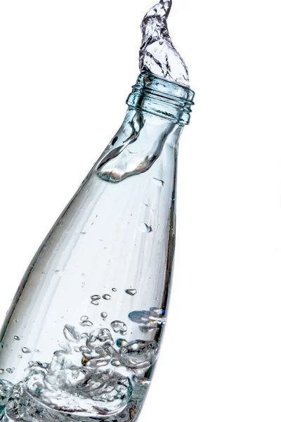 Skleněná láhev stříkající vodě izolovaných na bílém — Stock fotografie