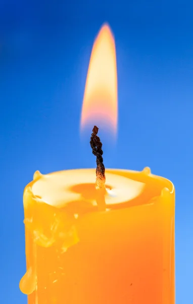 Plamen svíčky přes modré pozadí — Stock fotografie
