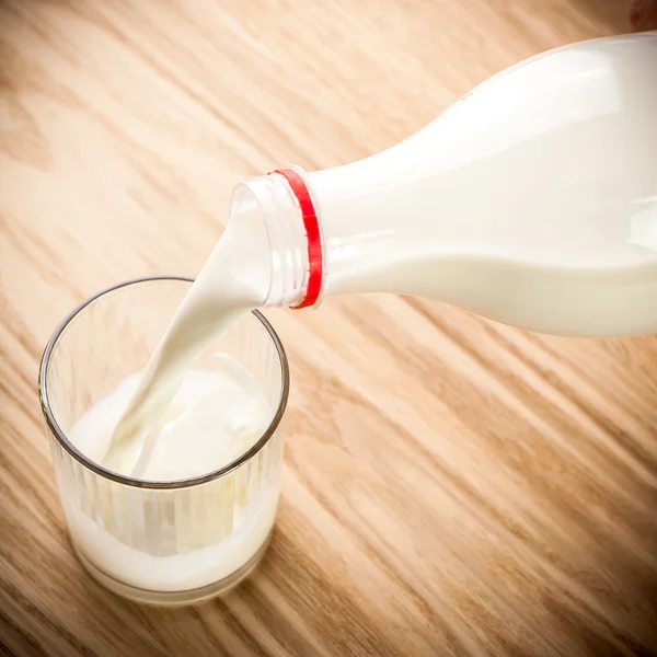 Mjölken hälls från flaska — Stockfoto