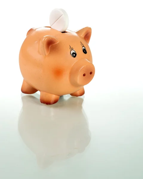 Piggy bank met witte tablet op de achterkant — Stockfoto