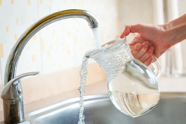 Filing glass pitcher with water — Stock Photo, Image